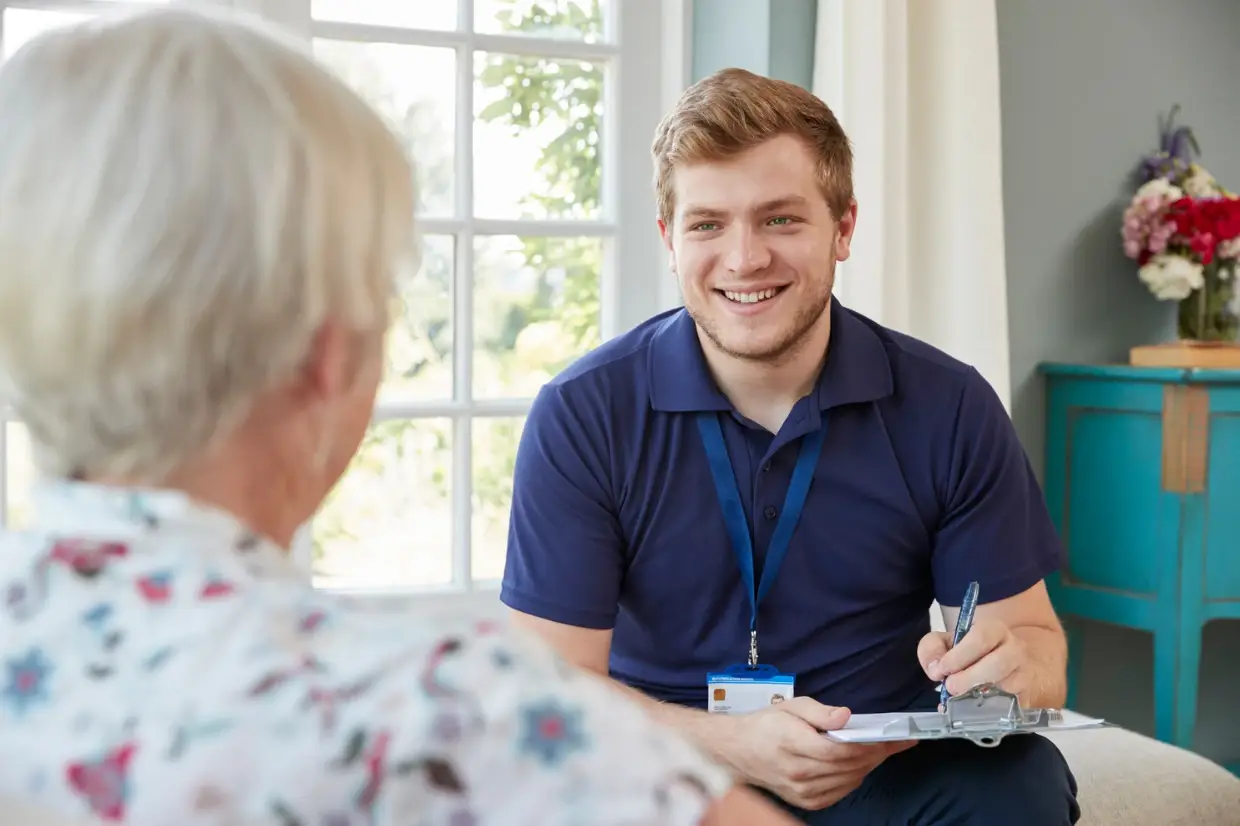 A community health worker in conversation with an older person at home